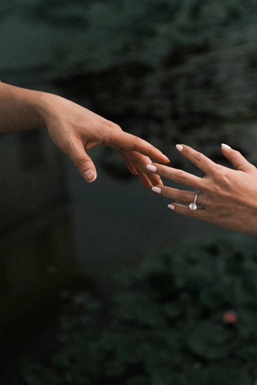 Maria and Scott reaching for one another, with Maria's engagement ring in view